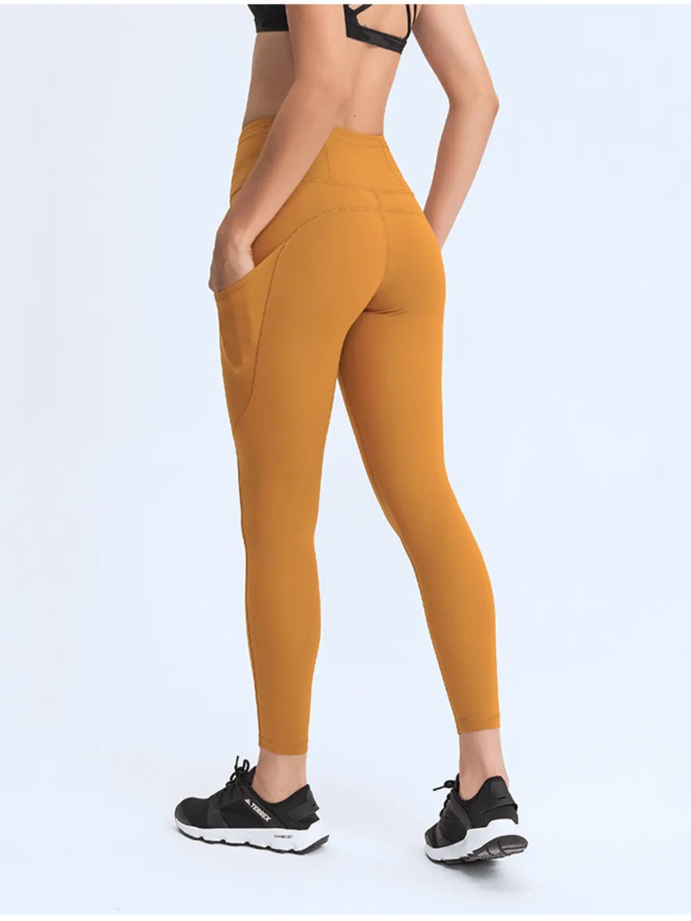 Mustard yellow leggings worn by a person on a white background
