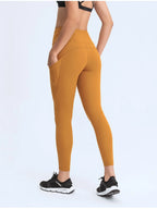 Mustard yellow leggings worn by a person on a white background