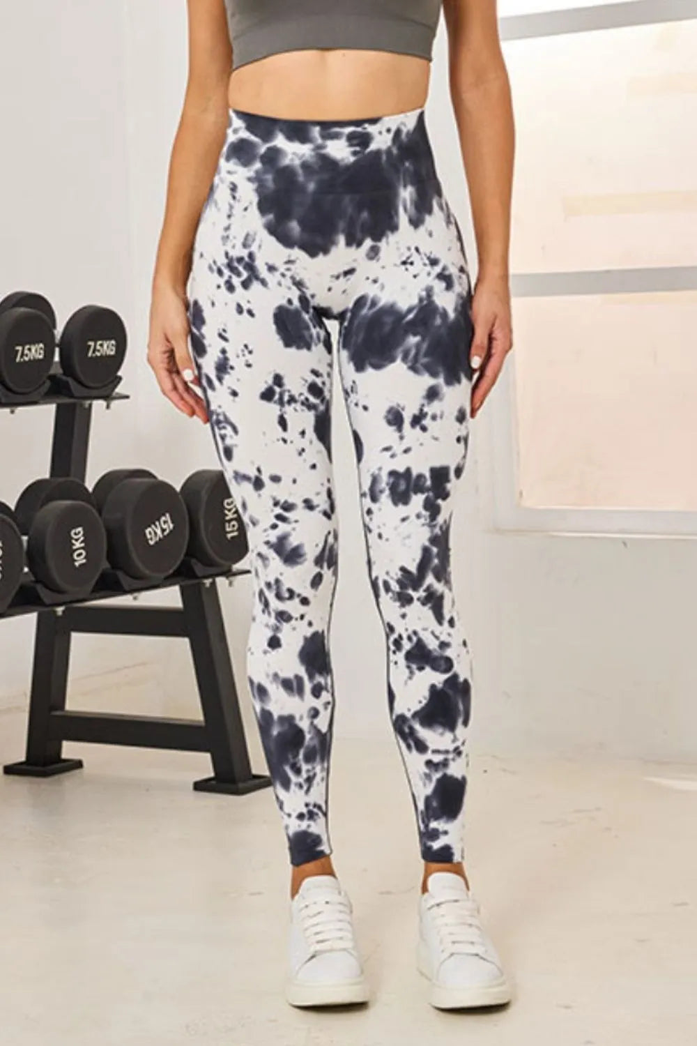 Person wearing tie-dye leggings in a gym setting with weights in the background