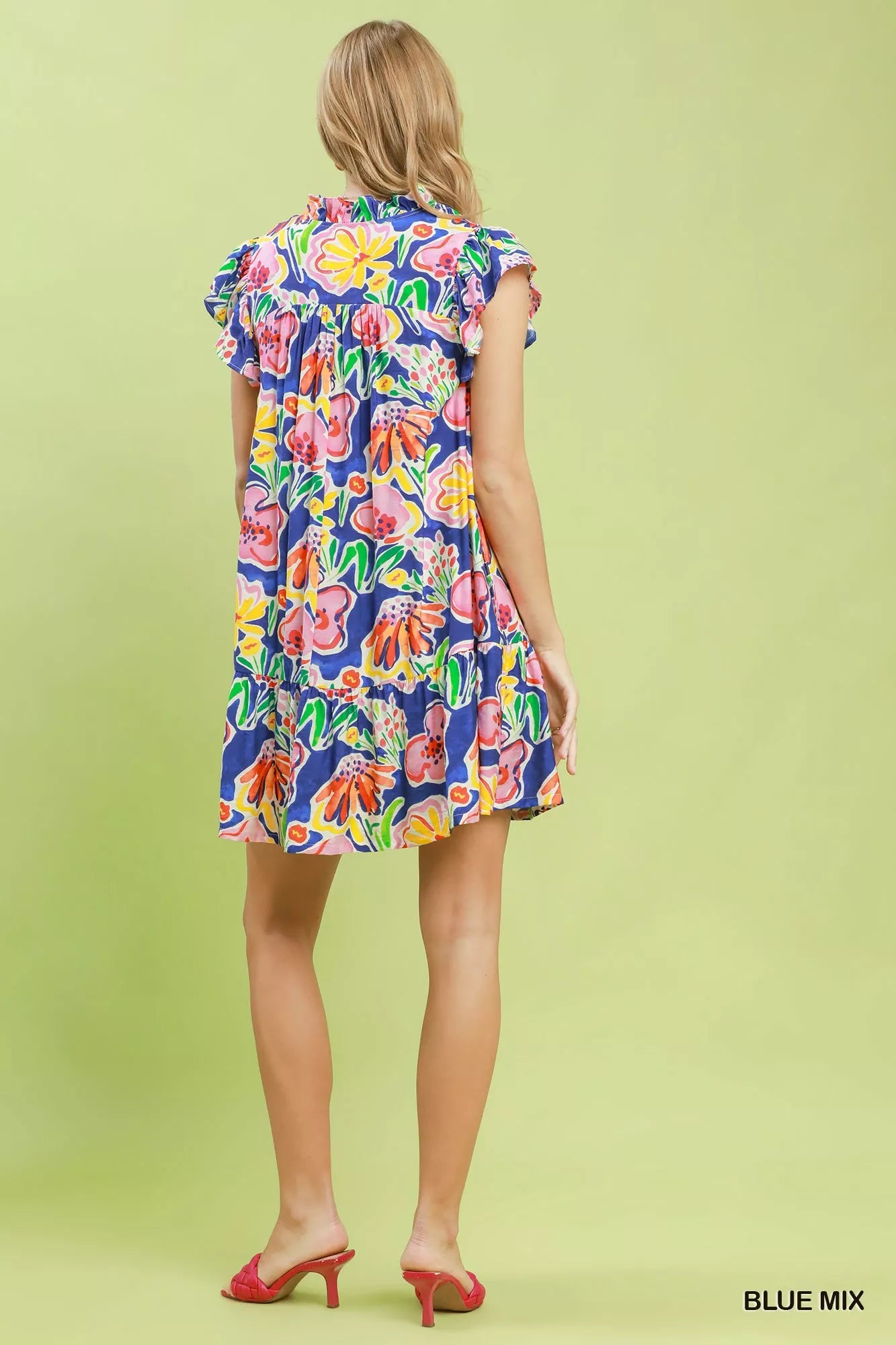 Woman wearing a colorful floral dress on a light green background