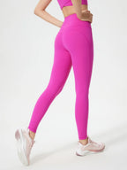 Person wearing bright pink leggings on a white background