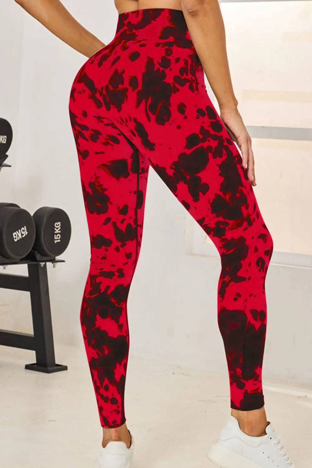 Red and black patterned leggings worn by a person in a gym setting.