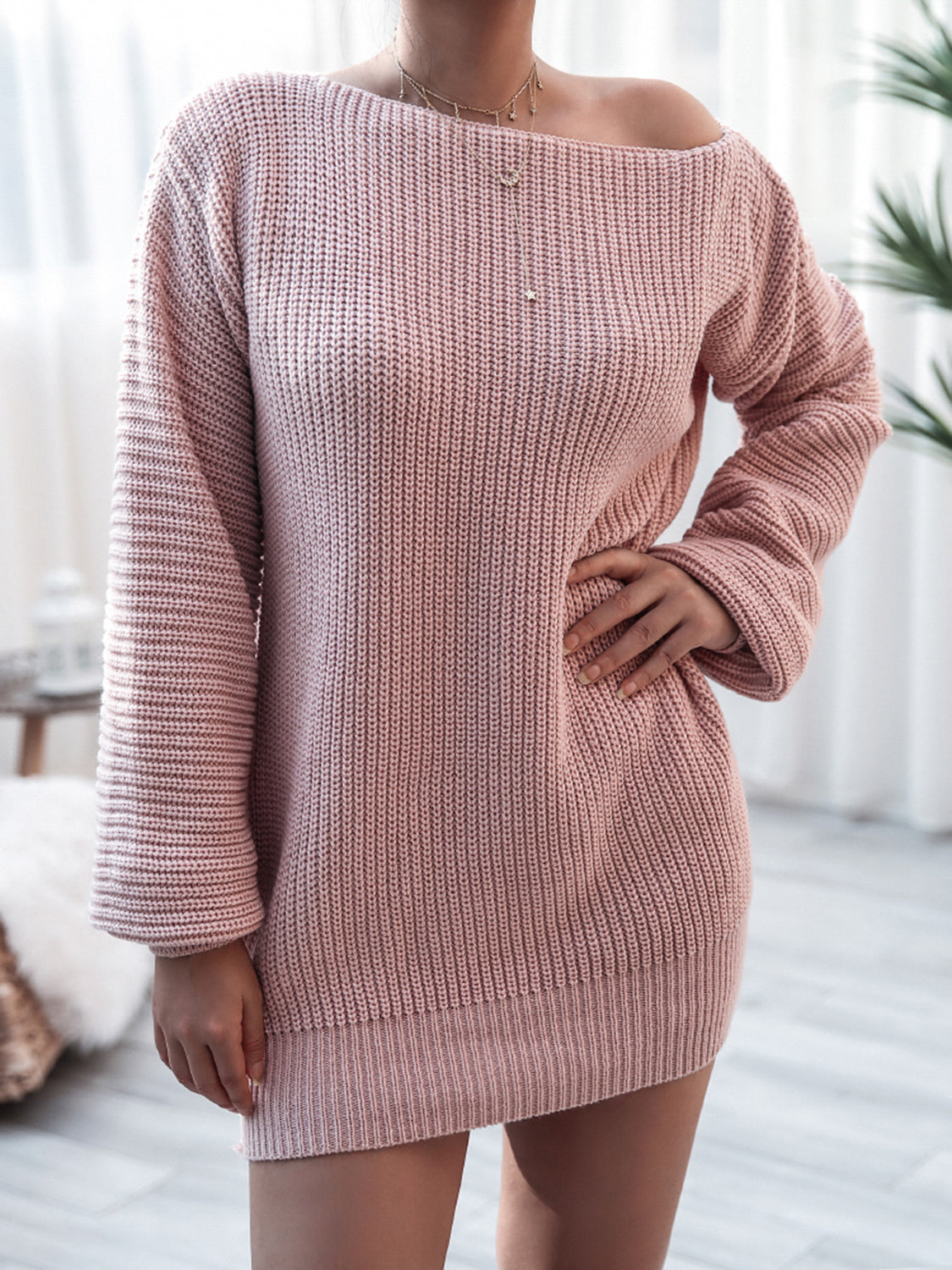 Pink knitted dress worn by a person indoors with a blurred background