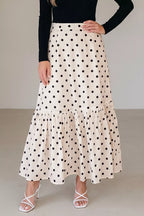 Woman wearing a polka dot skirt with a plain background