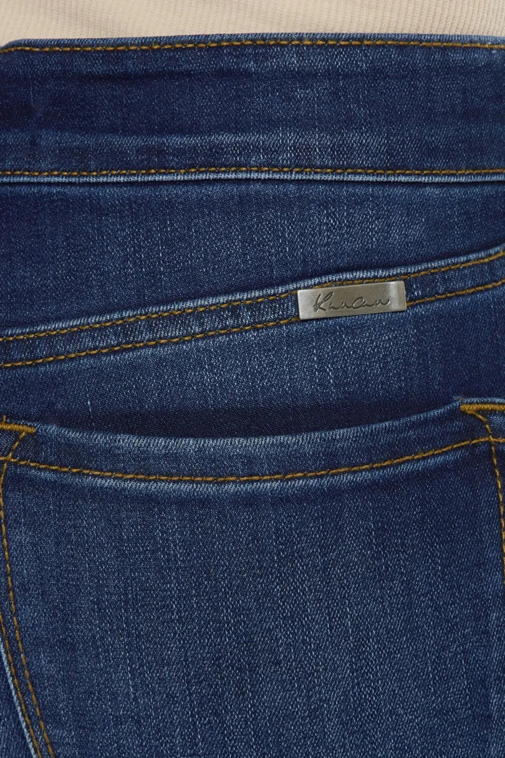 Close-up of a blue denim pocket with a brand label.