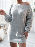Person wearing a gray knitted dress in a bright room.