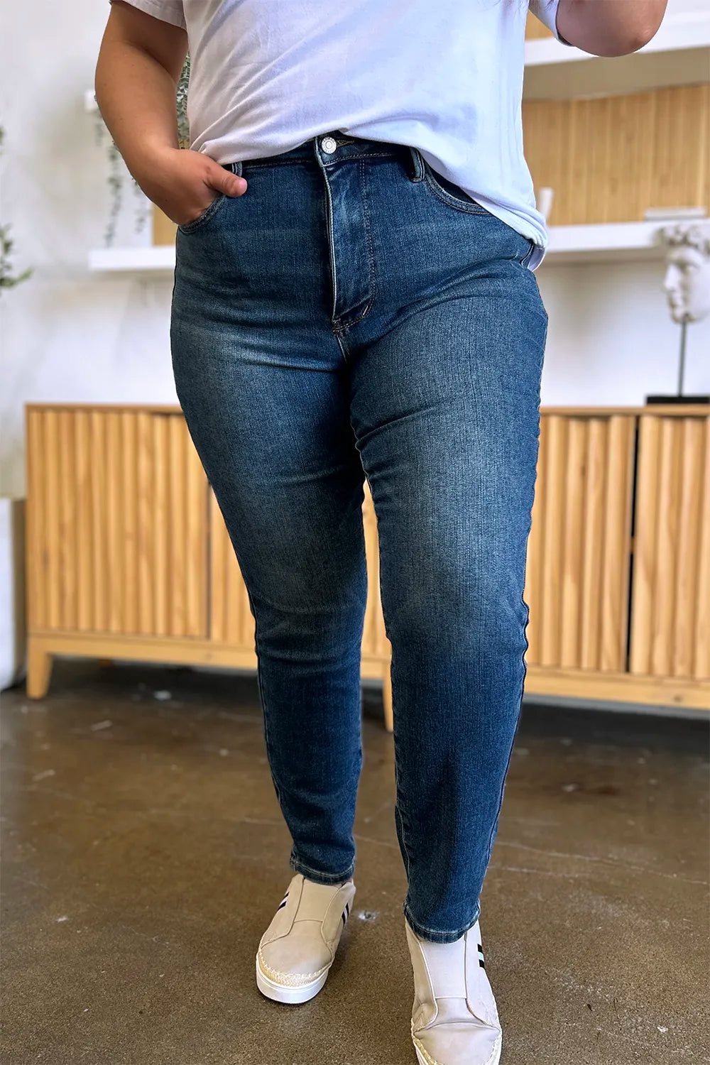 Person wearing blue jeans and a white shirt in an indoor setting