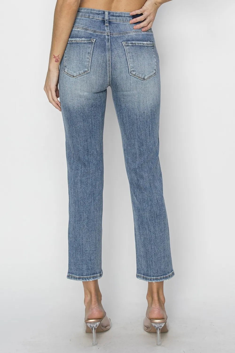 Blue jeans worn by a person on a white background