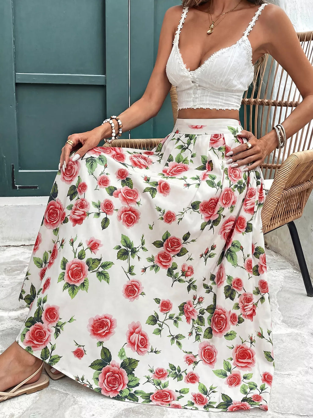 Woman wearing a white floral skirt and top sitting on a chair.