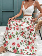 Woman wearing a white floral skirt and top sitting on a chair.