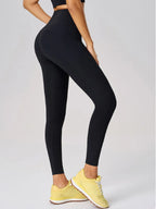 Person wearing black leggings and yellow sneakers on a light gray background