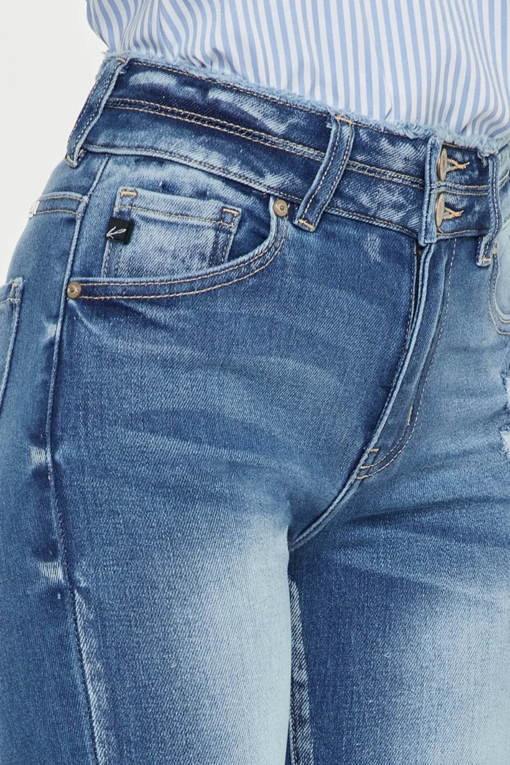 Close-up of blue jeans with a focus on the waistband and front pocket.