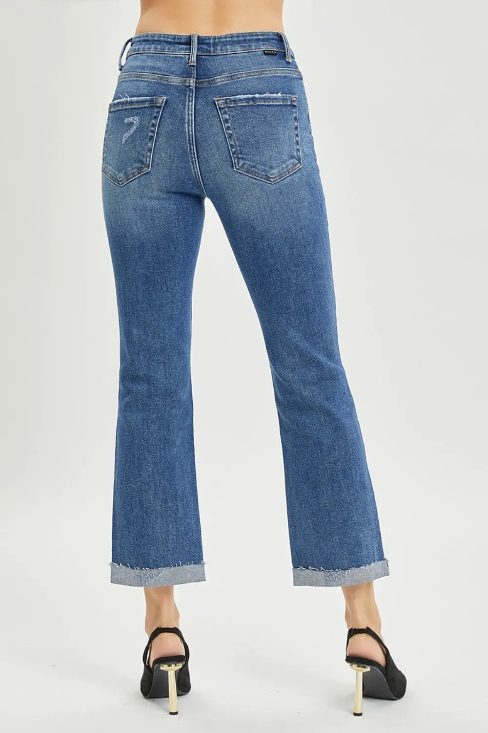 Blue jeans worn by a person on a white background