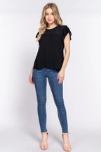 Woman wearing a black top and blue jeans on a white background