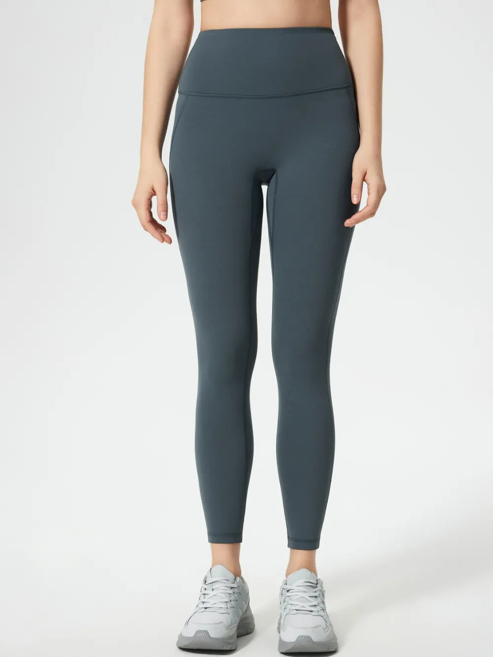 Person wearing dark gray leggings on a white background