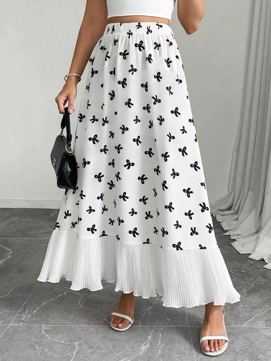 Person wearing a white skirt with black floral patterns on a gray floor.