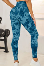 Person wearing blue tie-dye leggings in a gym setting