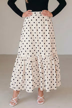 Person wearing a polka dot skirt with a plain background