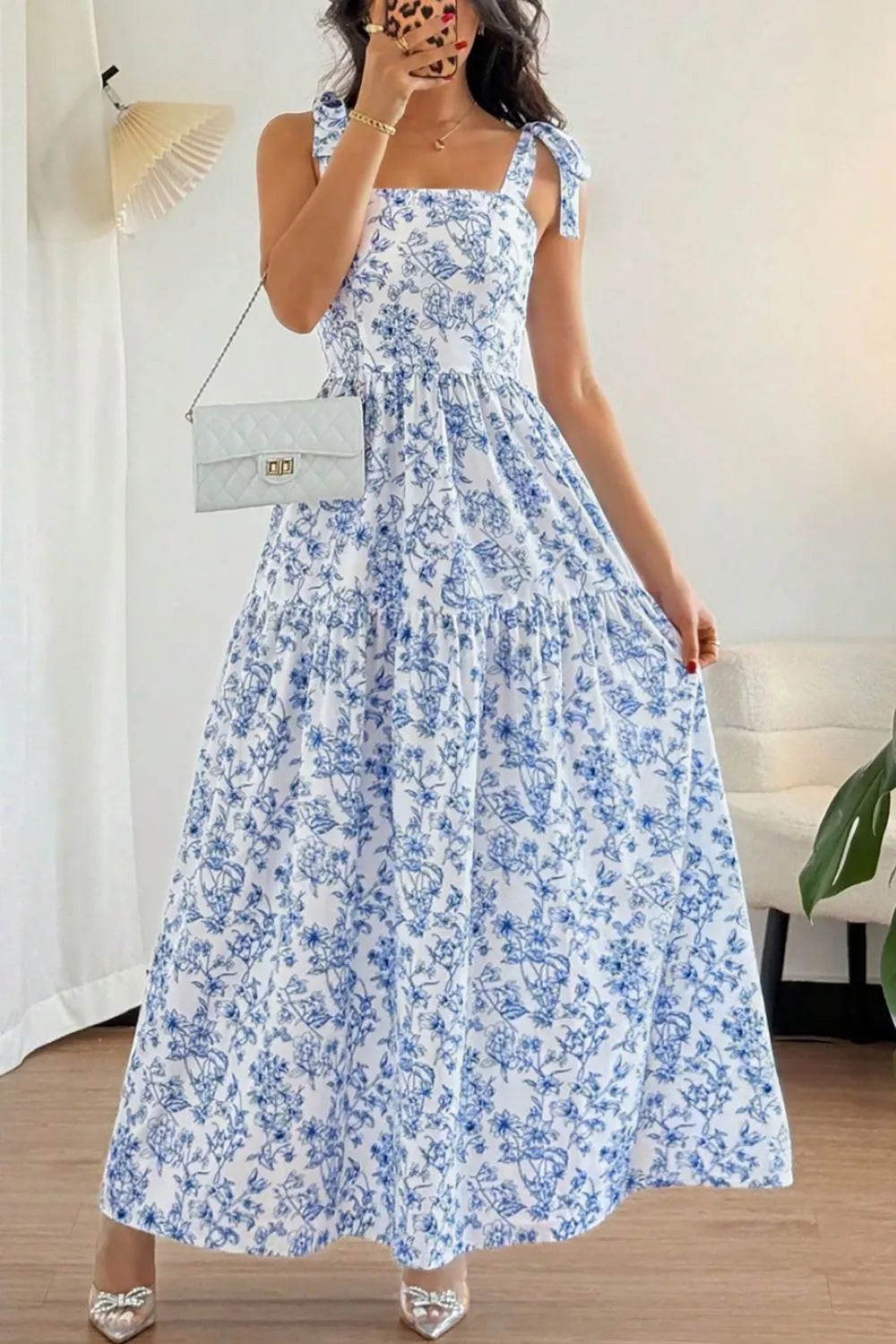 Woman wearing a blue floral dress indoors.