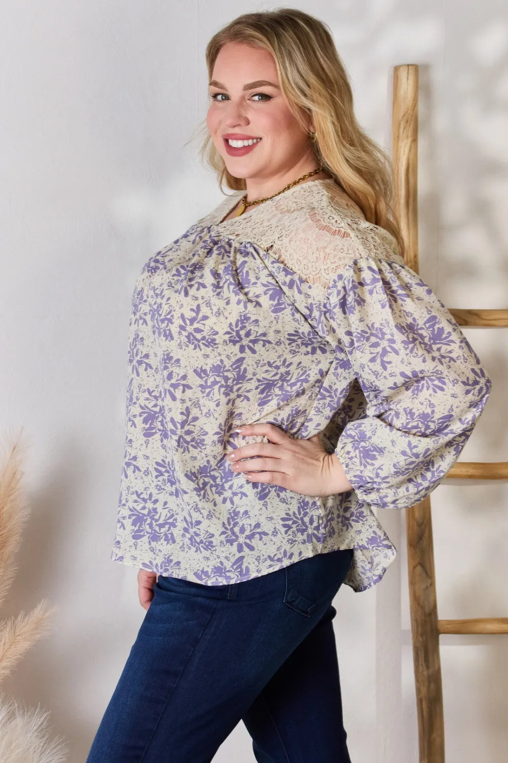 Woman wearing a floral blouse with long sleeves against a neutral background