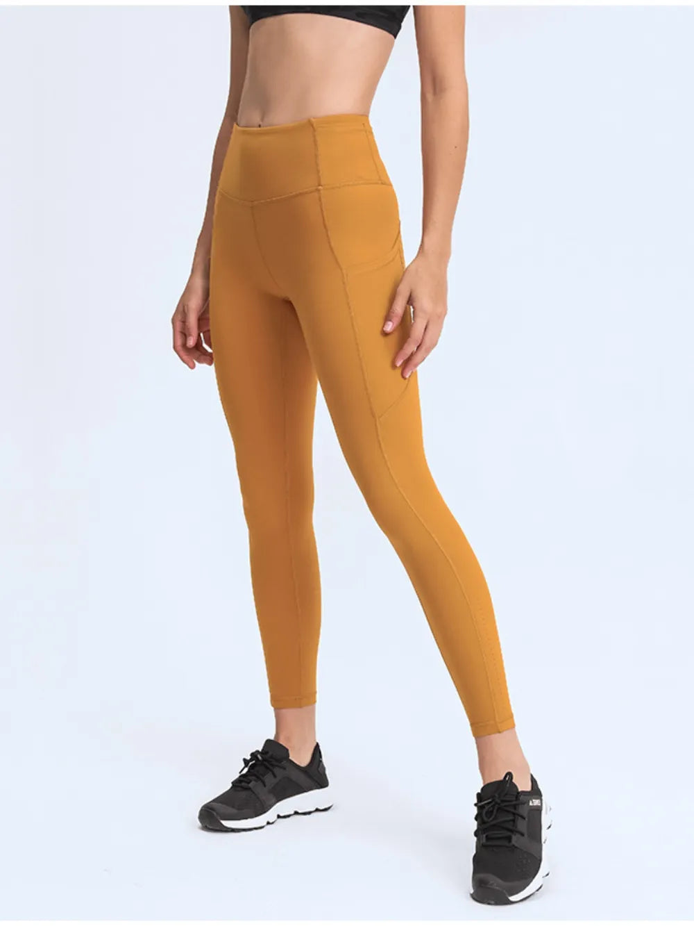 Mustard yellow leggings worn by a person on a white background