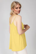 Woman wearing a yellow sleeveless top against a plain background