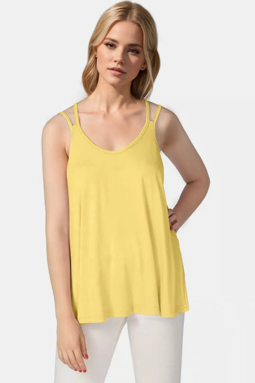 Woman wearing a yellow tank top against a white background