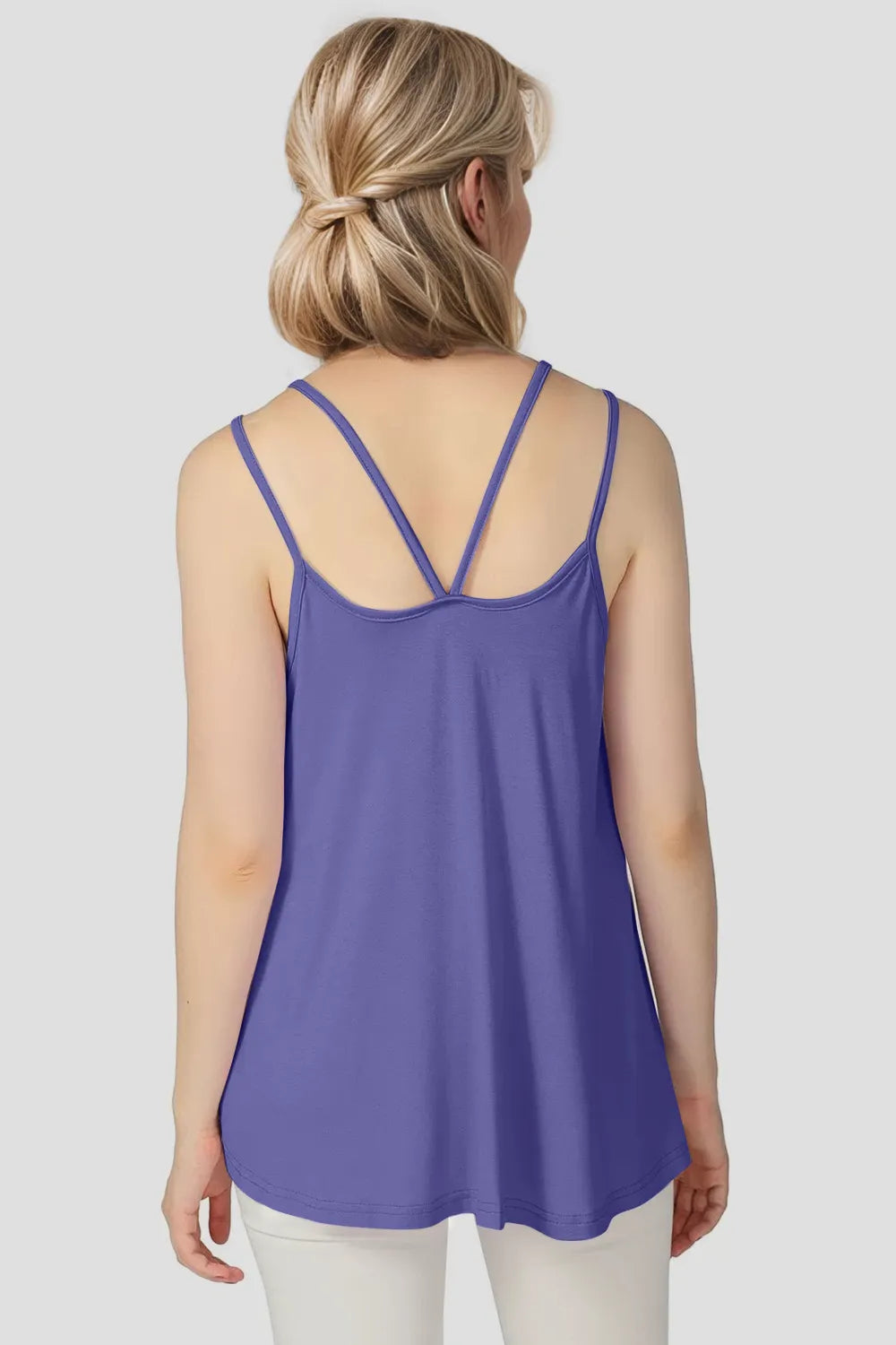Woman wearing a purple tank top on a plain background