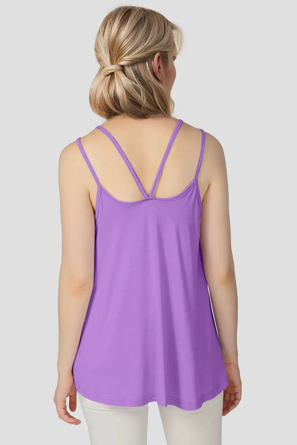 Woman wearing a purple tank top on a plain background