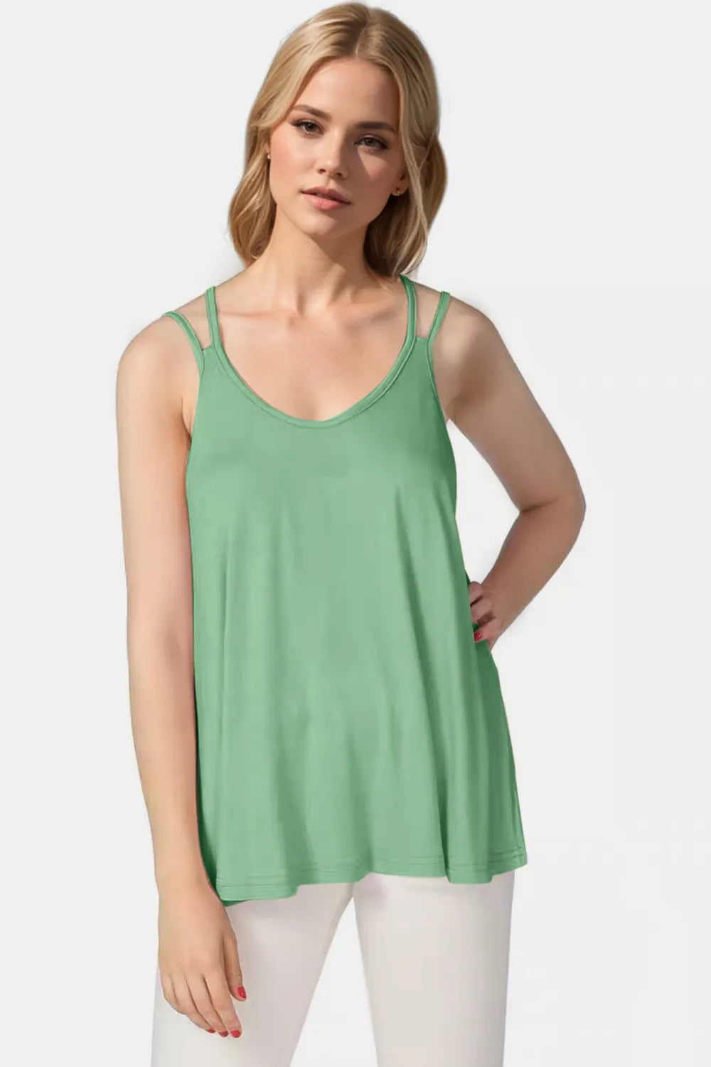 Woman wearing a green tank top against a white background
