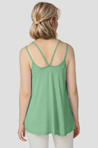 Woman wearing a green tank top on a plain background