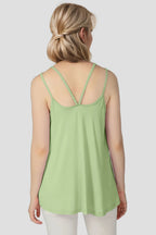 Woman wearing a light green tank top on a plain background