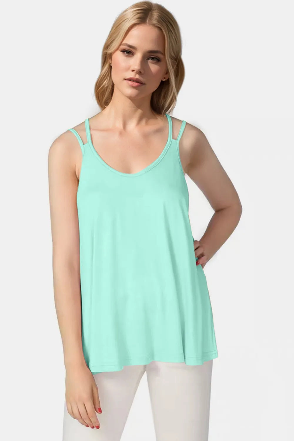 Woman wearing a light green tank top against a white background