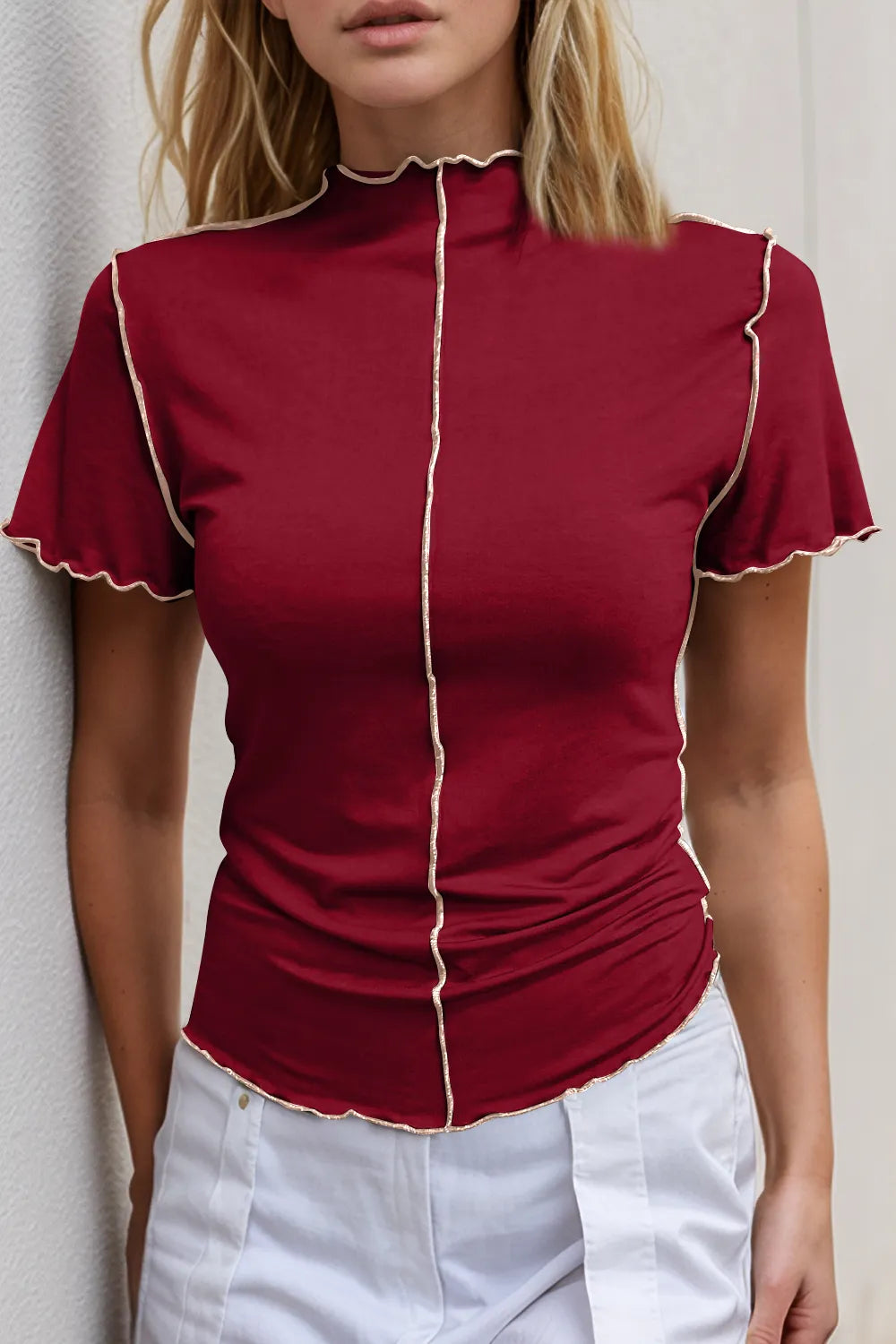 Red blouse with white trim worn by a person against a neutral background