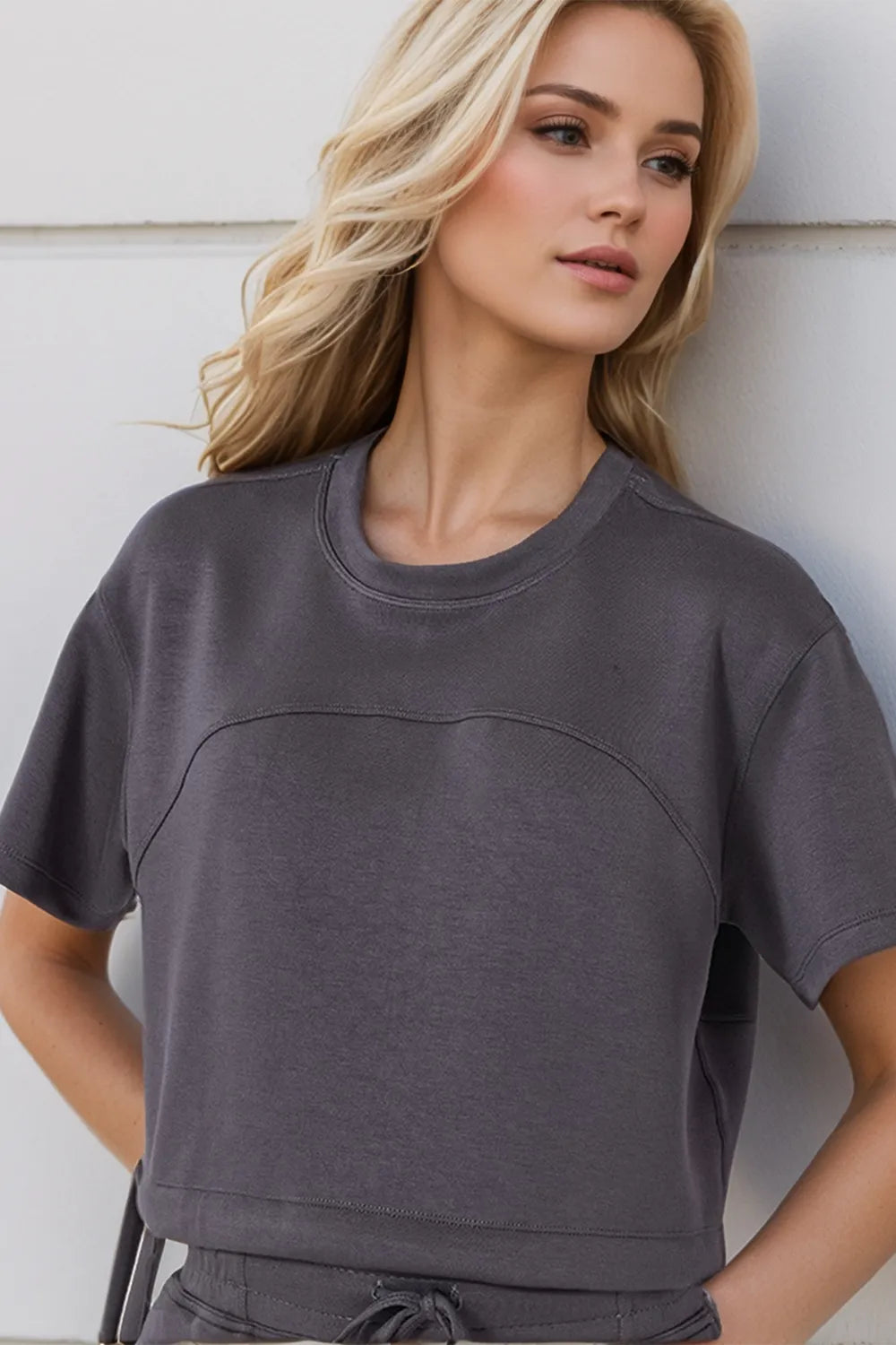 Woman wearing a gray sweatshirt against a light background