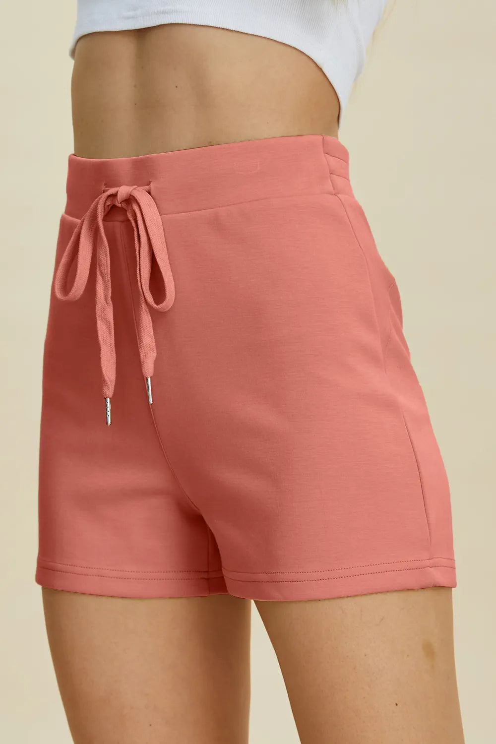 Pink shorts with a drawstring on a beige background