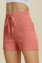 Pink shorts with a drawstring on a beige background