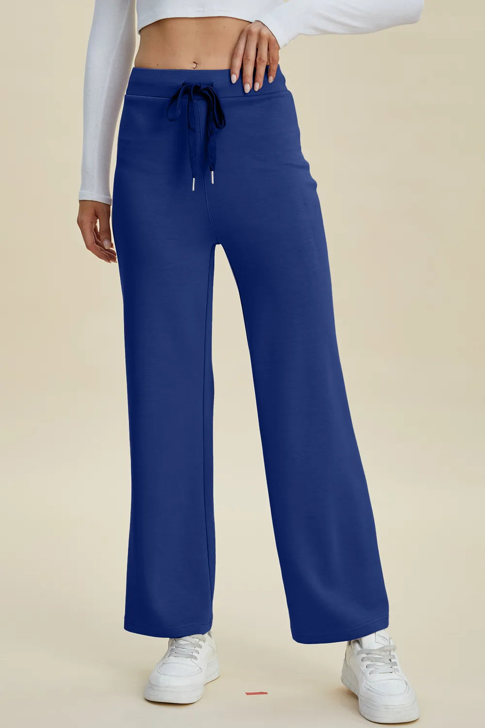 Blue pants worn by a person on a beige background