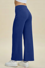Blue wide-leg pants worn by a person on a beige background