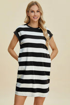Woman wearing a black and white striped dress on a beige background