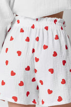 White shorts with red heart pattern worn by a person.
