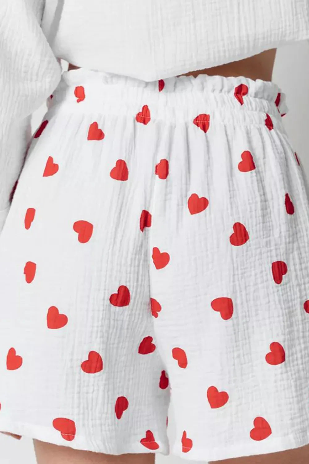 White shorts with red heart pattern worn by a person.