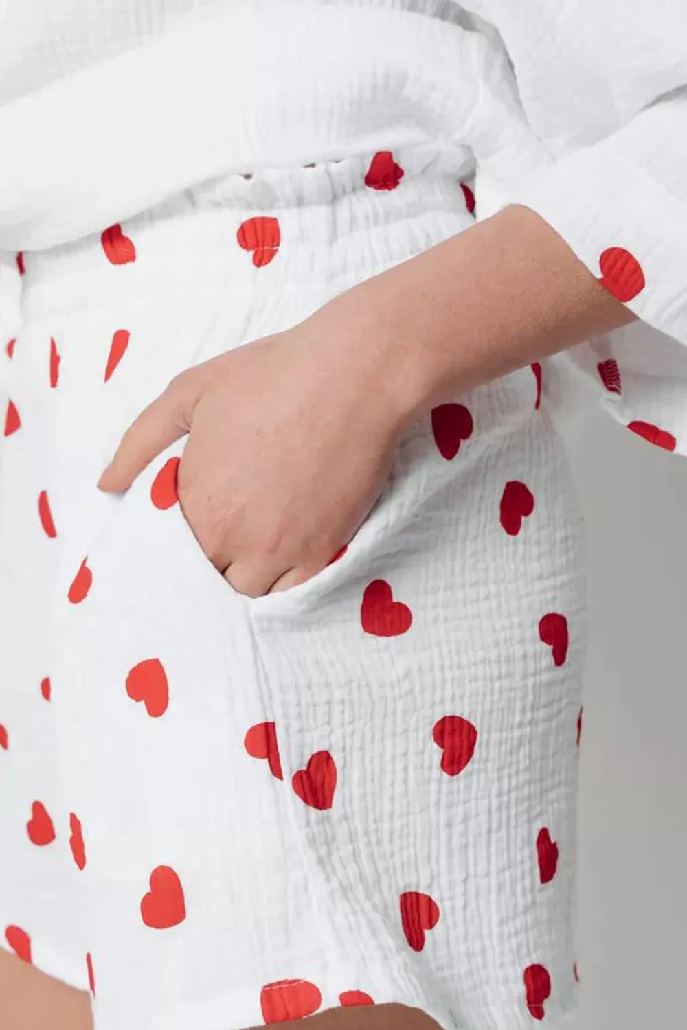 White pants with red heart patterns worn by a person.