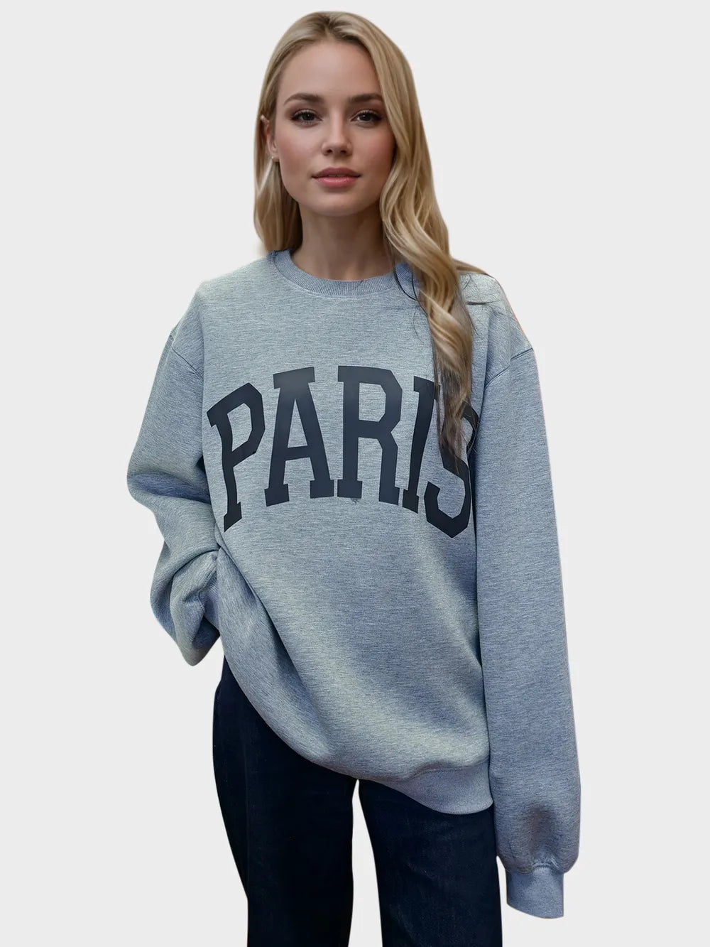 Woman wearing a gray sweatshirt with 'PARIS' printed on it against a white background