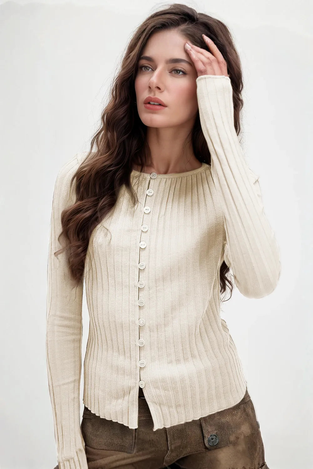 Woman wearing a beige ribbed sweater against a white background