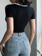 Person wearing a black t-shirt and light blue jeans against a neutral background
