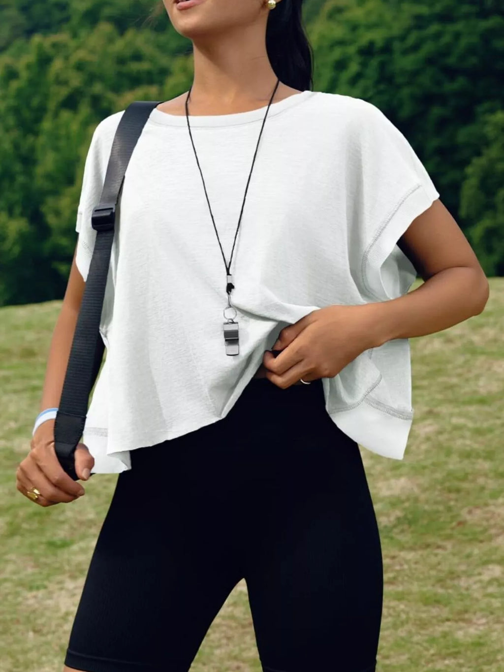 Person wearing a white top and black leggings outdoors