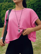 Person wearing a pink top and black pants outdoors