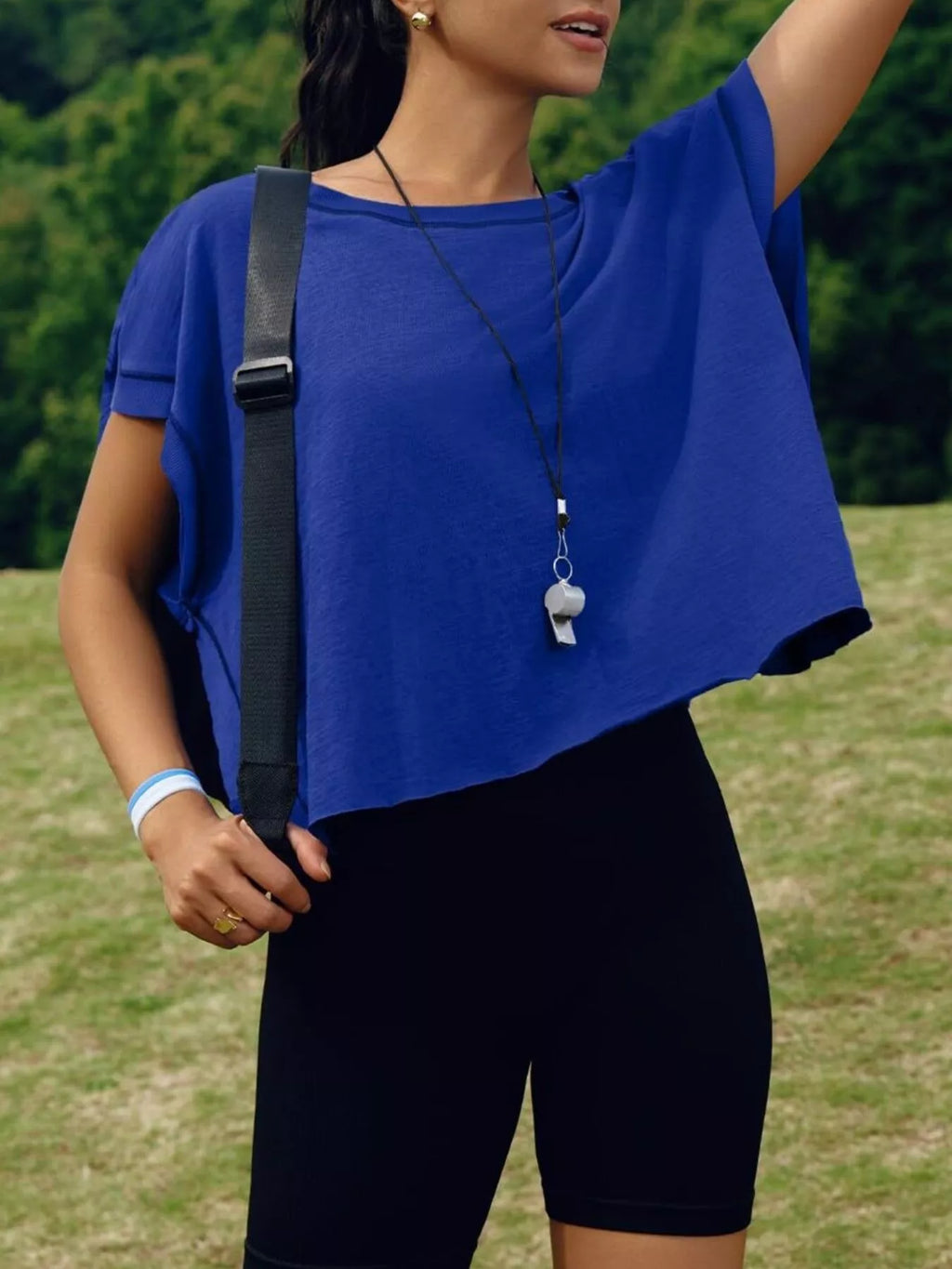 Person wearing a blue top and black shorts outdoors