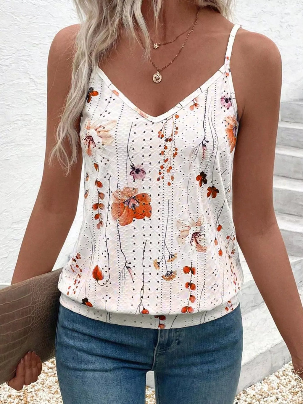 Woman wearing a floral print tank top with a white background
